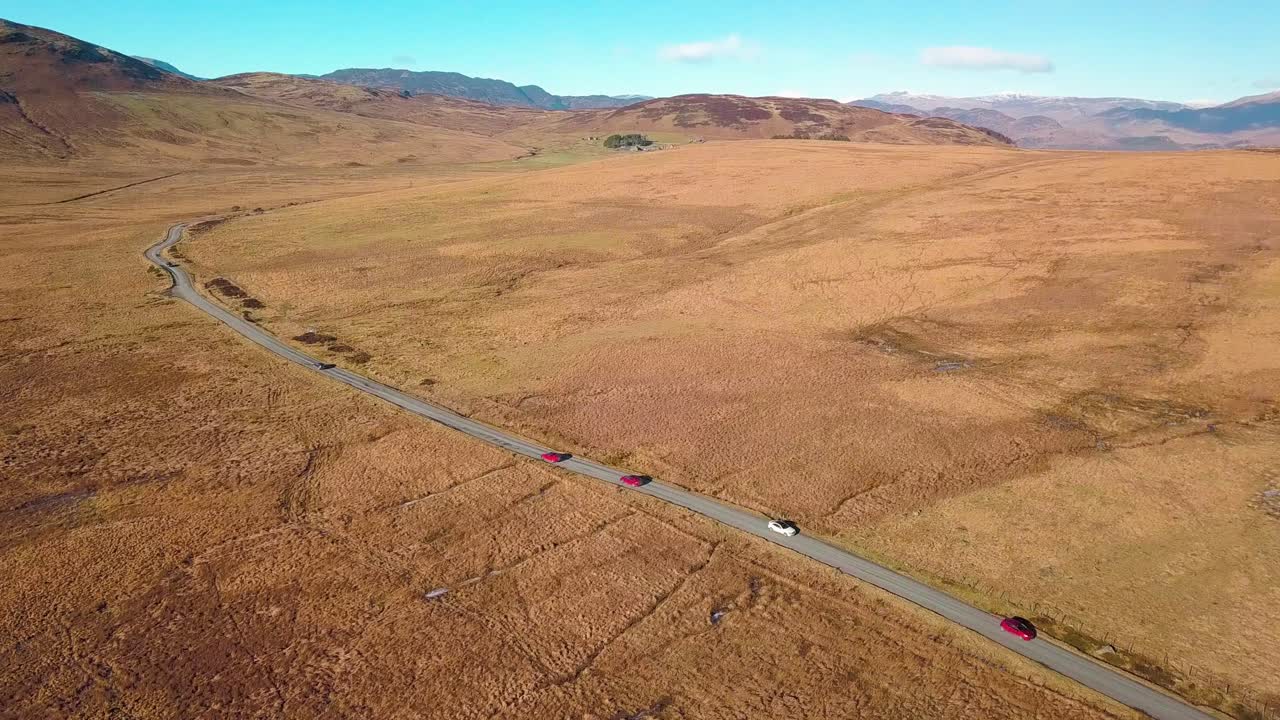 disparo de dron hacia adelante mientras se inclinaba hacia abajo volando sobre una carretera en las tierras altas de escocia
