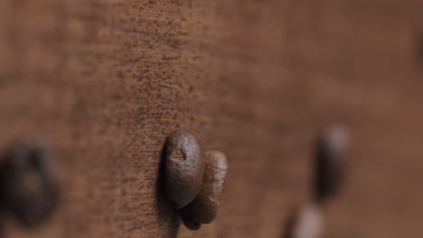 los granos de café tostados caen sobre una mesa de madera - toma del producto