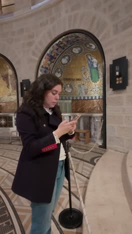 tourist using smartphone inside dormition abbey in jerusalem. slow motion.