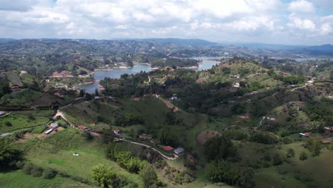 Vista-Aérea-Del-Hermoso-Paisaje-Verde-Alrededor-Del-Lago-Guatape,-Colombia