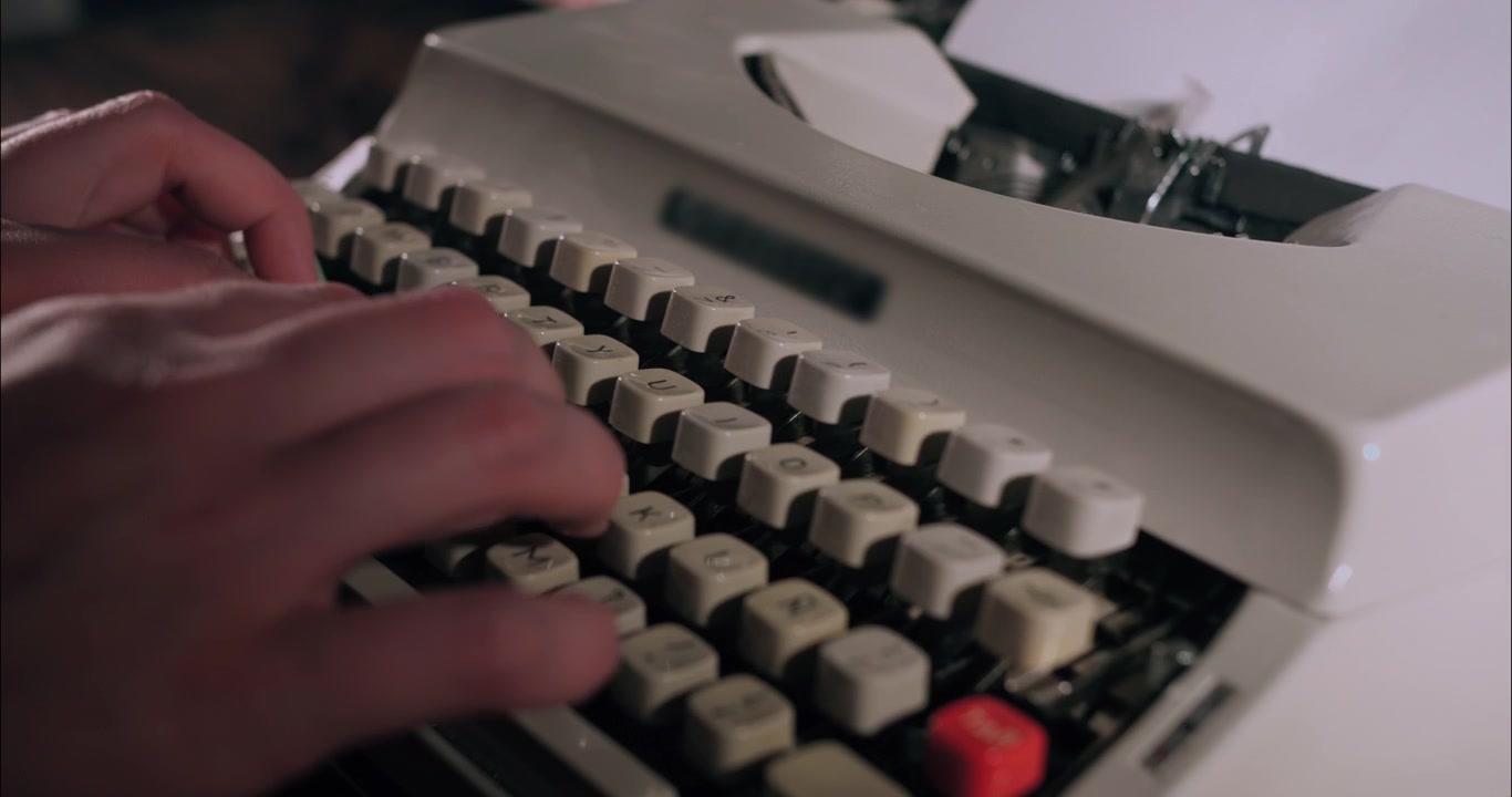 Primo piano di mani che digitano su una macchina da scrivere vintage