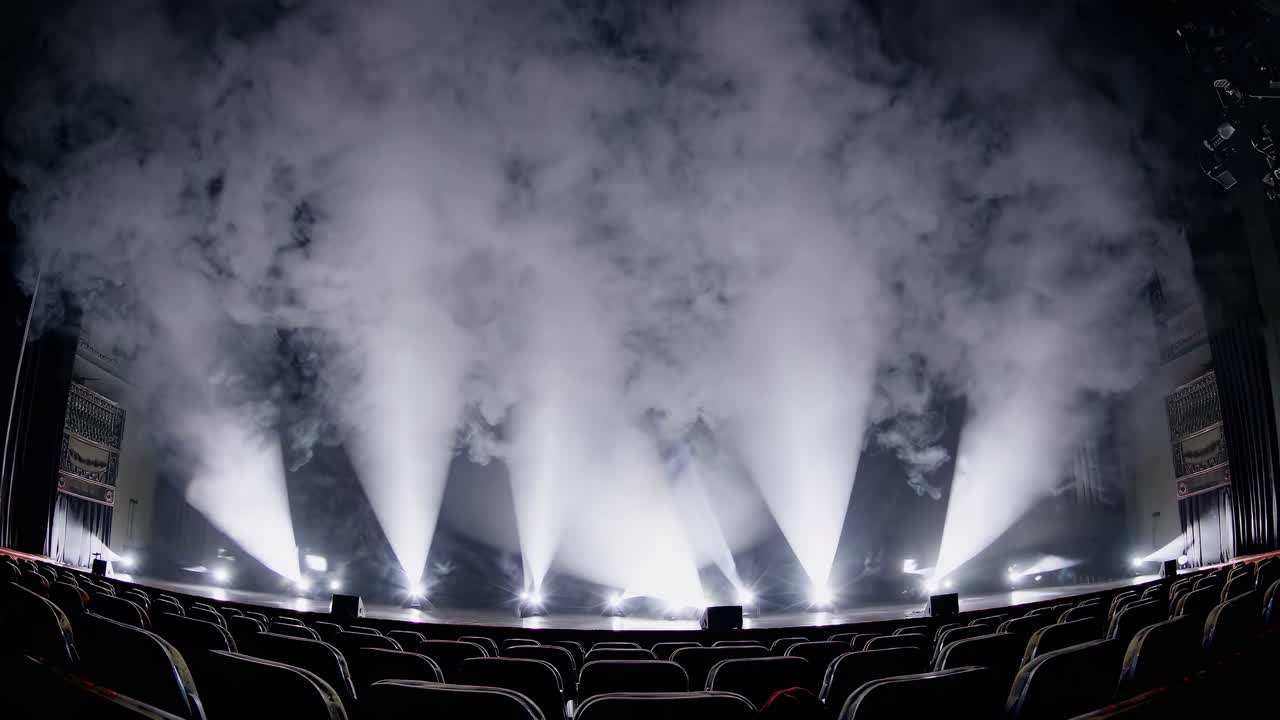 Scatto grandangolare di un palco con faretti colorati e nebbia, per un effetto scenico d’impatto e dinamico