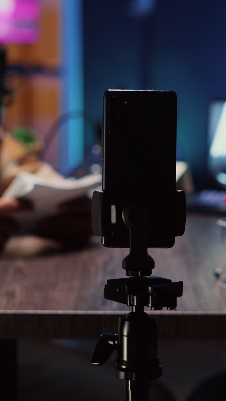 Vertical video Podcast host using smartphone on tripod to record guest telling interesting story