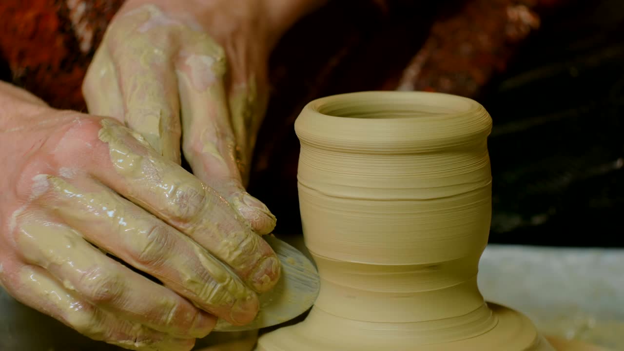 taza de conformación de alfarero profesional con herramienta especial en taller de cerámica