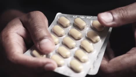 hands holding blister packs of pills