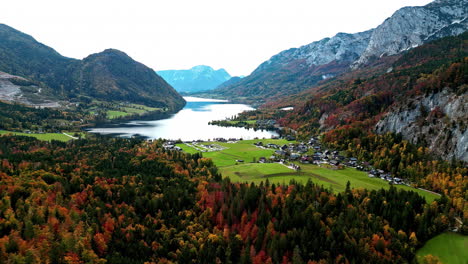 Aerial-drone-forward-moving-shot-over-agricultural-Surnadalsfjorden-town-surrounded-by-green-vegetation-along-mountain-slope-in-Norway