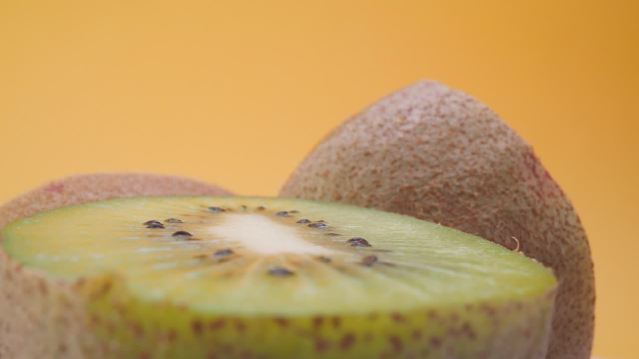 kiwi recién cortado contra un fondo amarillo