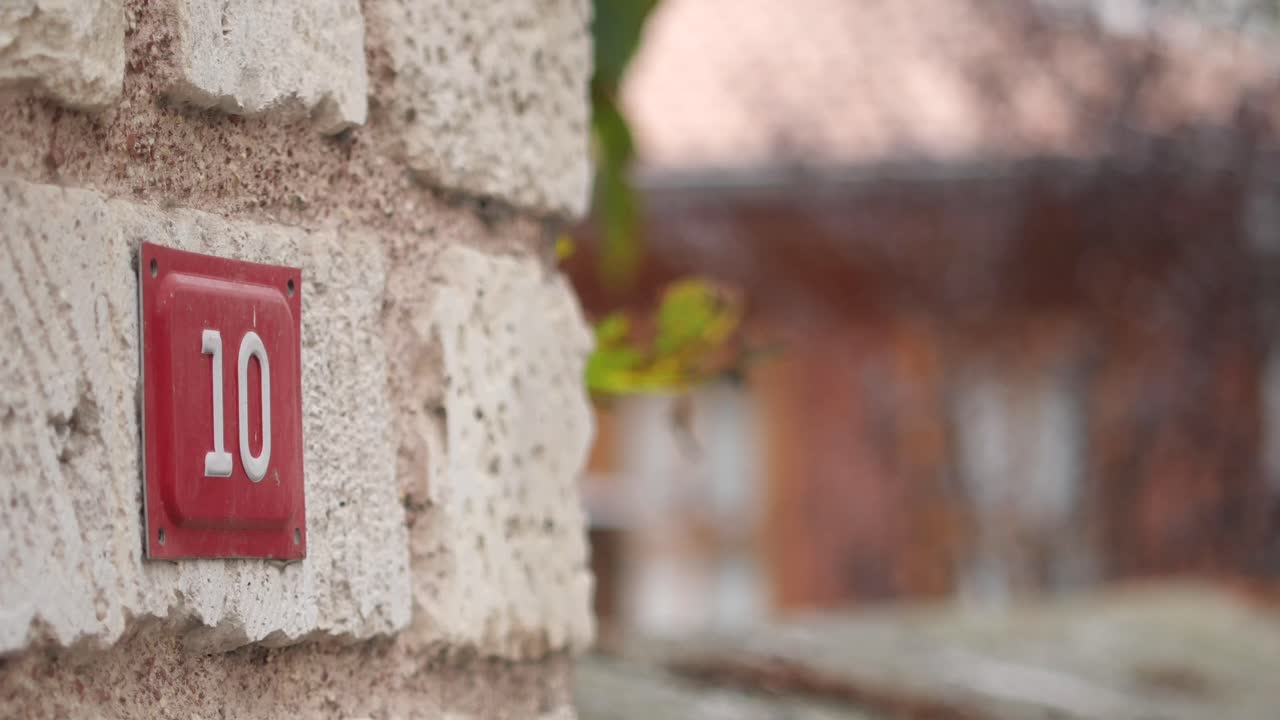 House number 10 on a brick wall