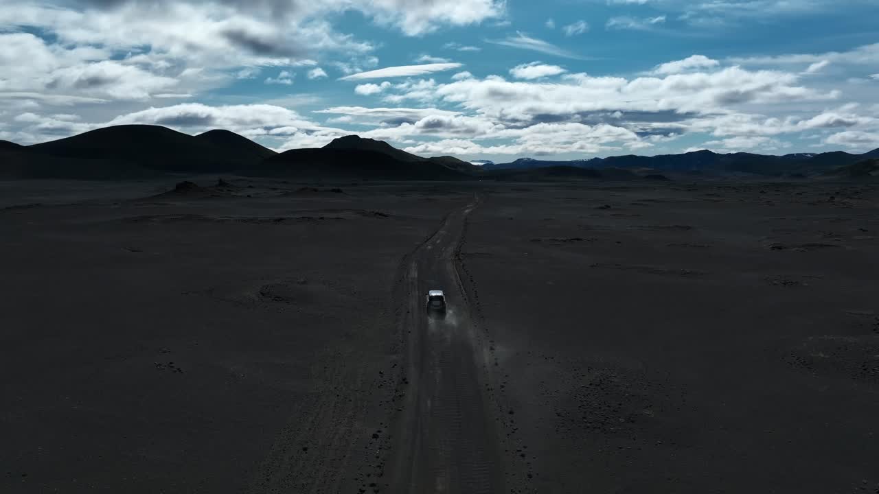 SUV Car driving away into wilderness of Iceland