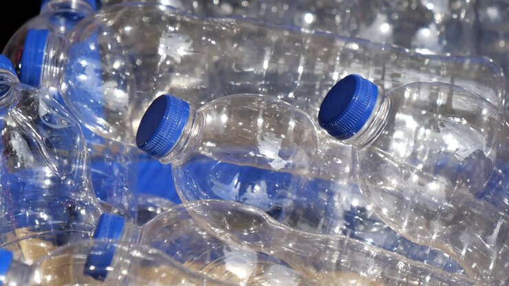 Stack of Clear Plastic Bottles with Blue Caps
