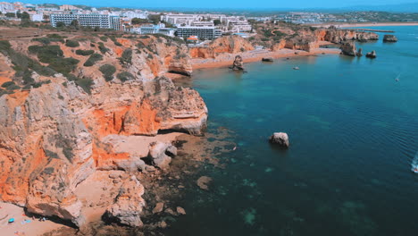 rocky cliffs and beautiful blue ocean during the summer in praia dona ana in the algarve in portugal, aerial drone view