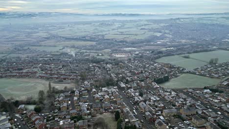 dramatic 4k cinematic aerial footage, depicting a rural, harsh english winter cold spell with mist and freezing temperatures