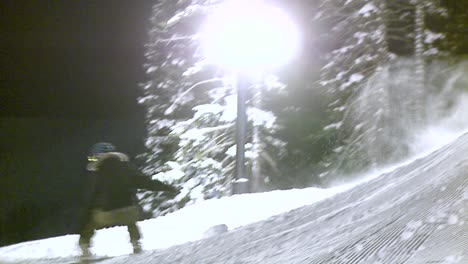 a snowboard rider hits a jump at night