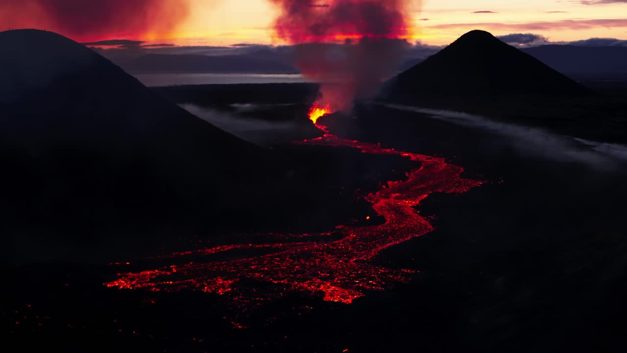 Litli-Hr&uacute;tur volcano eruption with lava flowing at sunset in Iceland, aerial