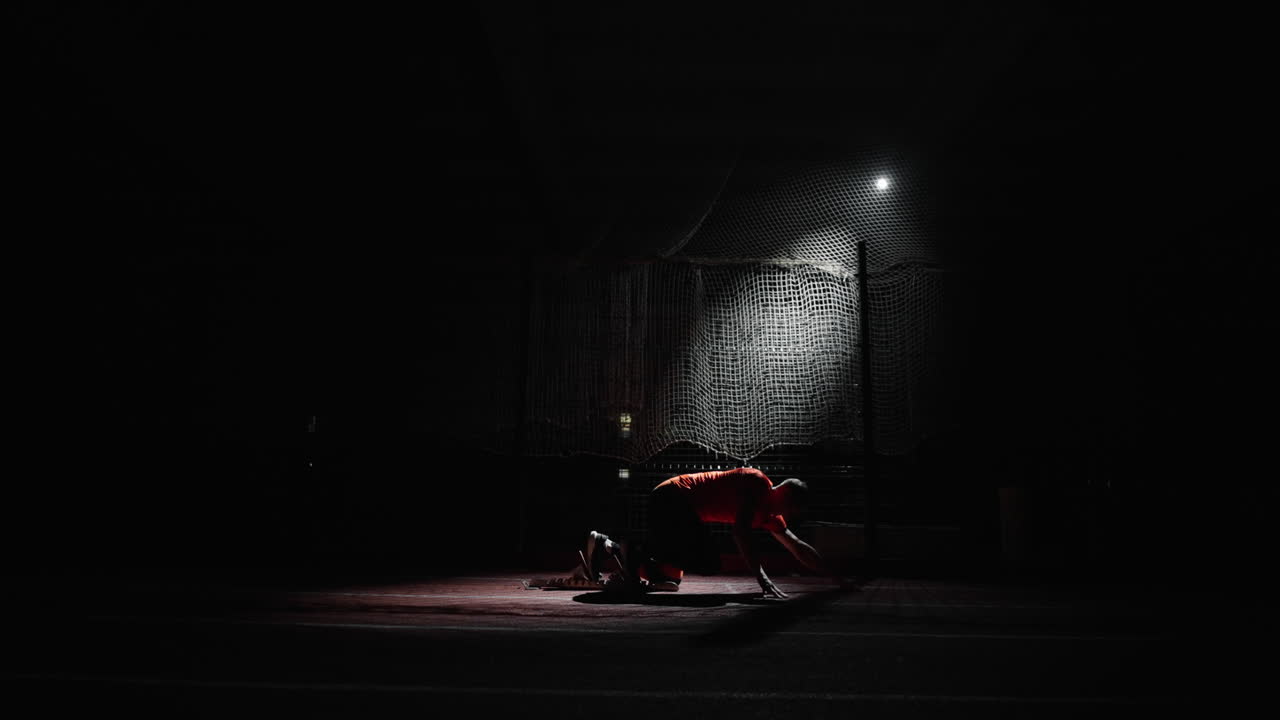 atleta preparándose para un sprint por la noche