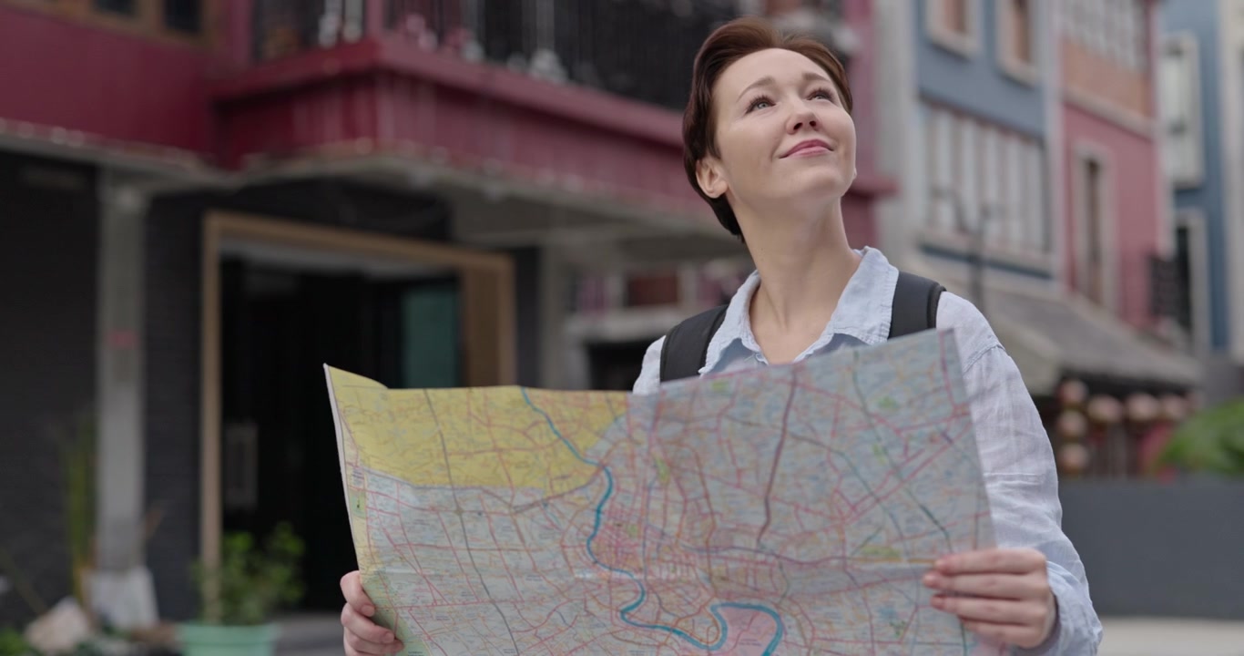 Happy Woman Tourist Looking at Map and Exploring City Street