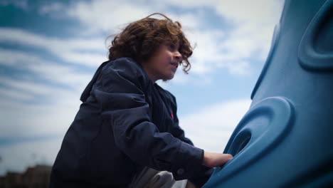 Cute-boy-climbing-up-a-playground-outside