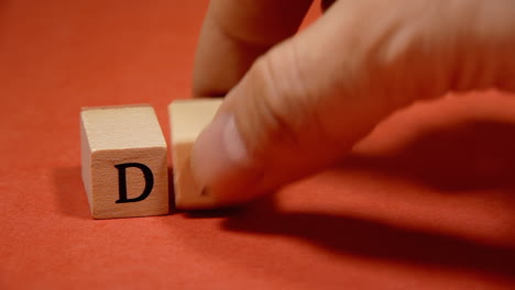 removing the word drug made with wooden letters from a red background