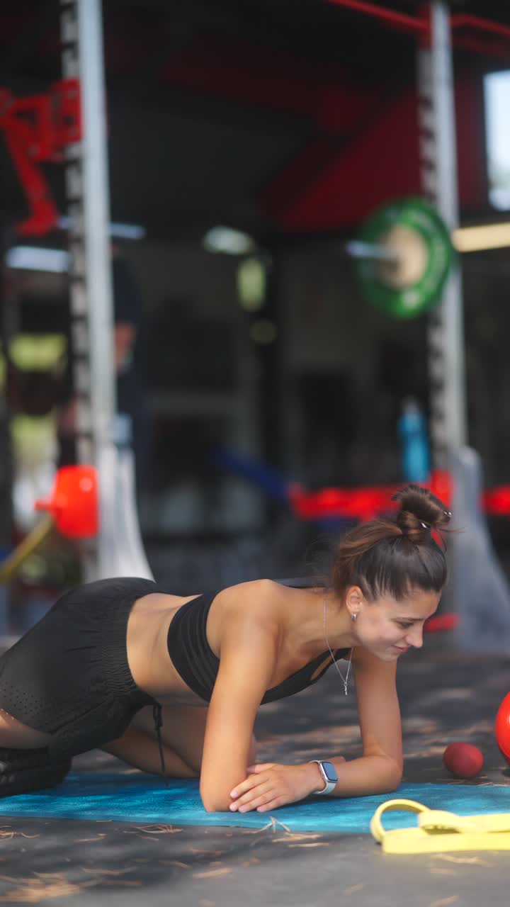 mujer haciendo un ejercicio de tabla en un gimnasio