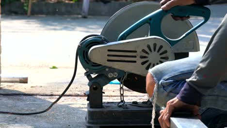 4k close up shot of construction worker welder hands using electric angular grinding machine for cutting iron steel bar and making sparks fire flakes from welding. safety work concept.