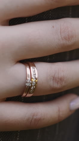 lady with gold wedding ring on finger strokes arm of husband wearing striped jacket closeup slow motion. young family love relationship. lovely couple