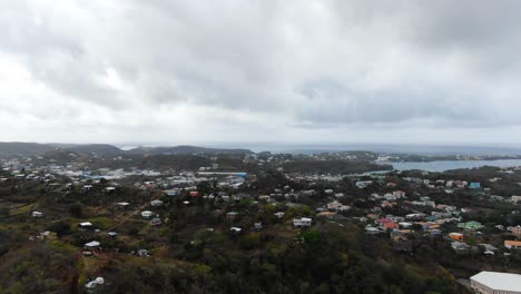 Town-on-the-island-of-Grenada,-wide-aerial-establisher