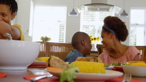 Front-view-of-black-sibling-having-food-at-dining-table-in-a-comfortable-home-4k