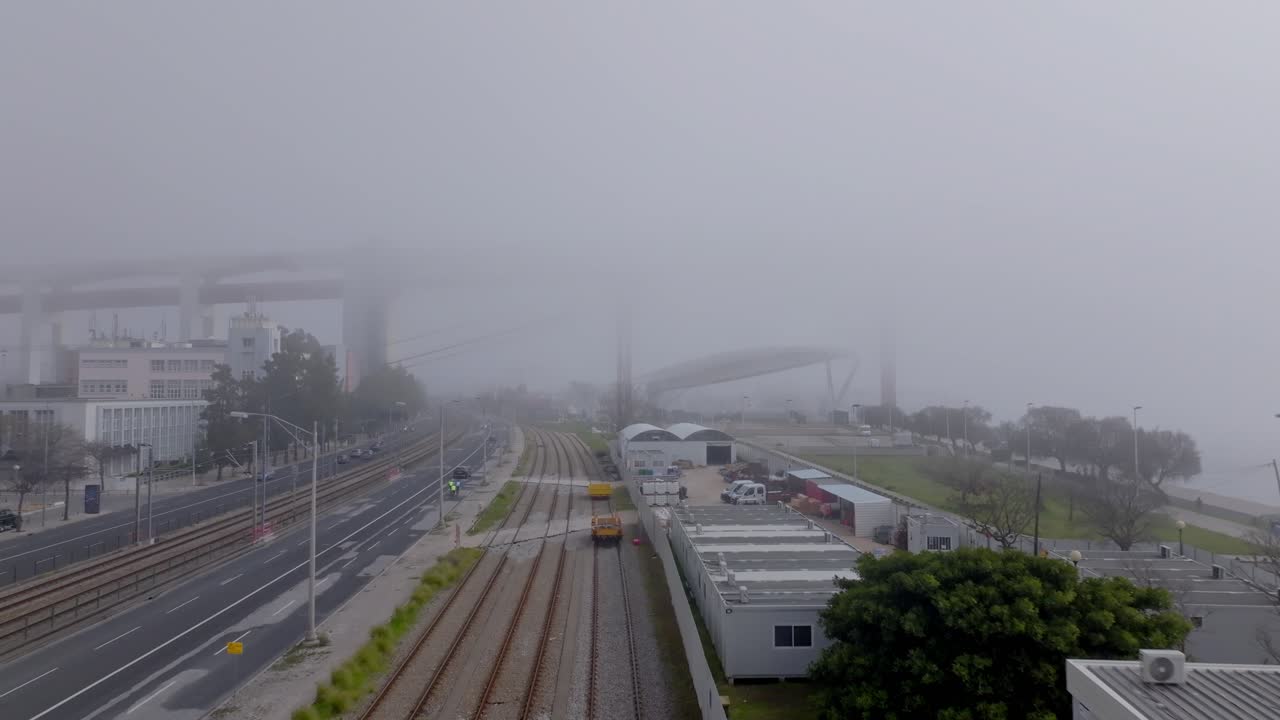 Drone shot following the train tracks in the fog.