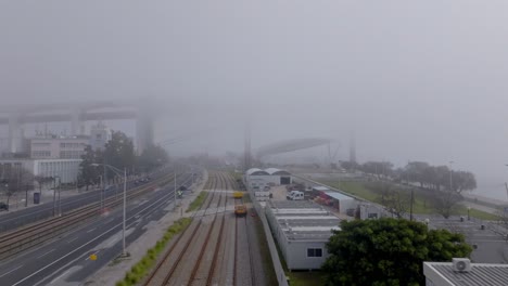 drone shot following the train tracks in the fog.