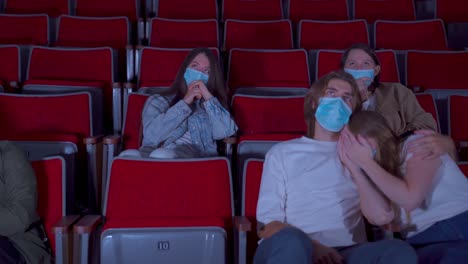 moviegoers in a theater wearing masks