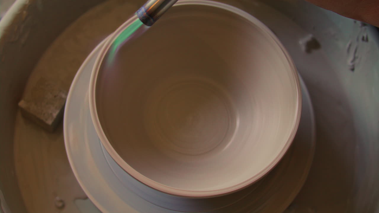 Top Down of Drying Clay Bowl with Torch Flame on Pottery Wheel