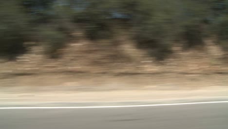 A-Car-Travels-Along-A-Scenic-Highway-Near-Los-Angeles-California-As-Seen-Through-The-Side-Window