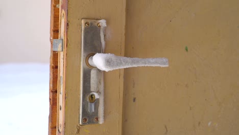 una mirada más cercana de la perilla de la puerta cubierta de hielo