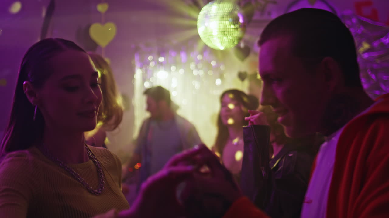 Dancing couple enjoy energetic movements on dance floor disco club closeup