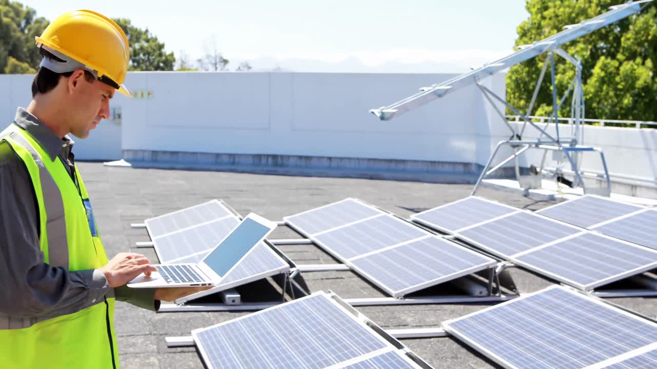 Male worker using laptop at solar station 4k