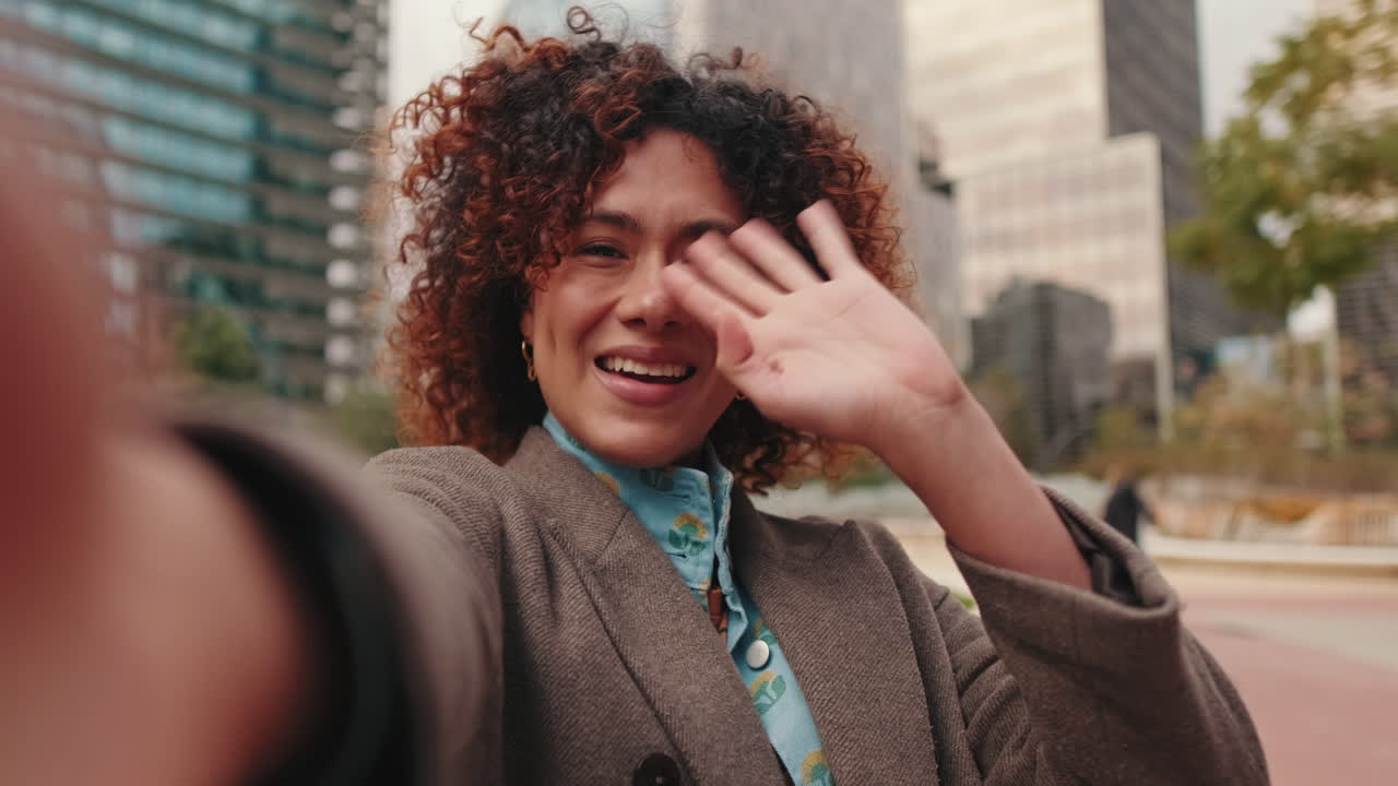 Happy Businesswoman Waving to Camera in City