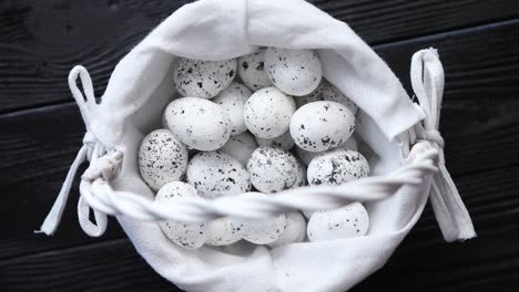 Quail-eggs-in-a-nest-on-a-black-rustic-wooden-background--Pascua-symbols