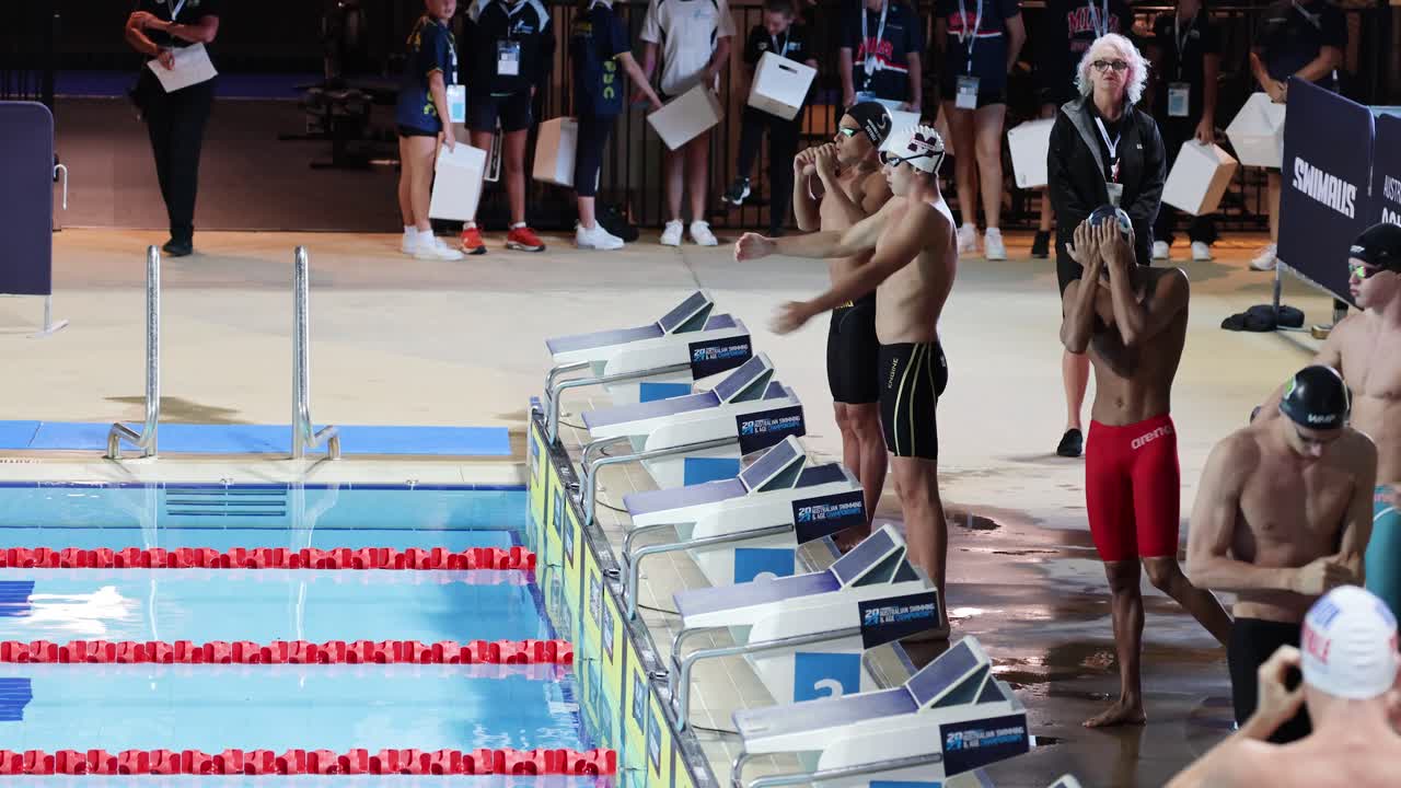 수영 대회 를 위해 수영장  에 준비 하고 있는 운동 선수 들