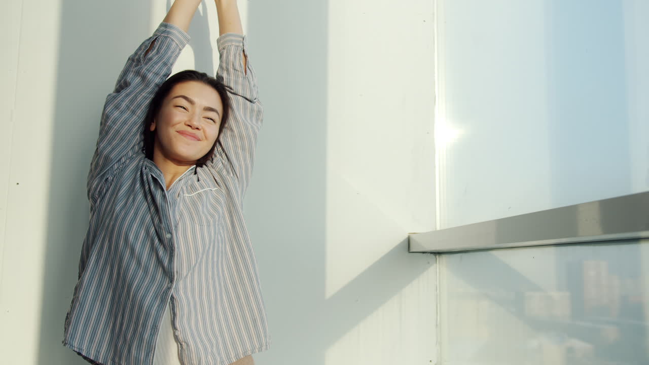 Woman Stretching on a Balcony at Sunrise
