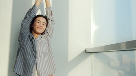 woman stretching on a balcony at sunrise