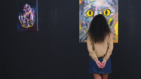 woman viewing abstract art and cat painting