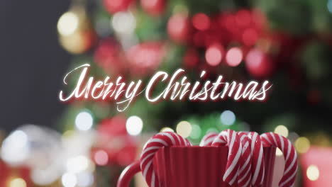 Merry-christmas-text-in-white-and-candy-canes-over-defocused-decorated-on-christmas-tree