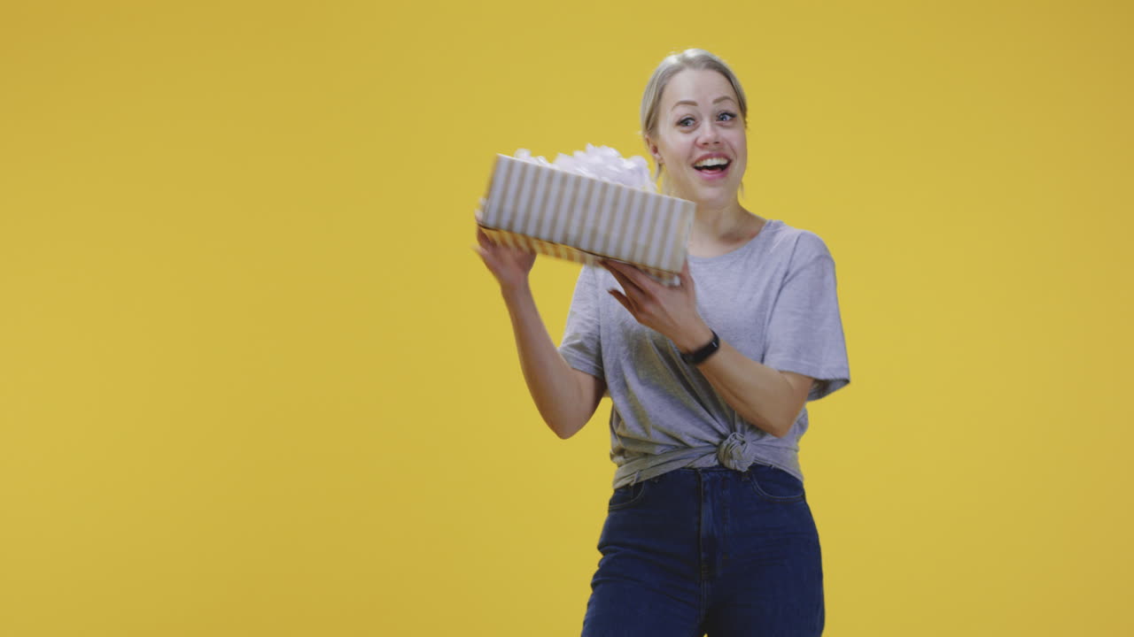 Young Woman Catching a Gift Box. Vertical shot of a young woman catching a gift box