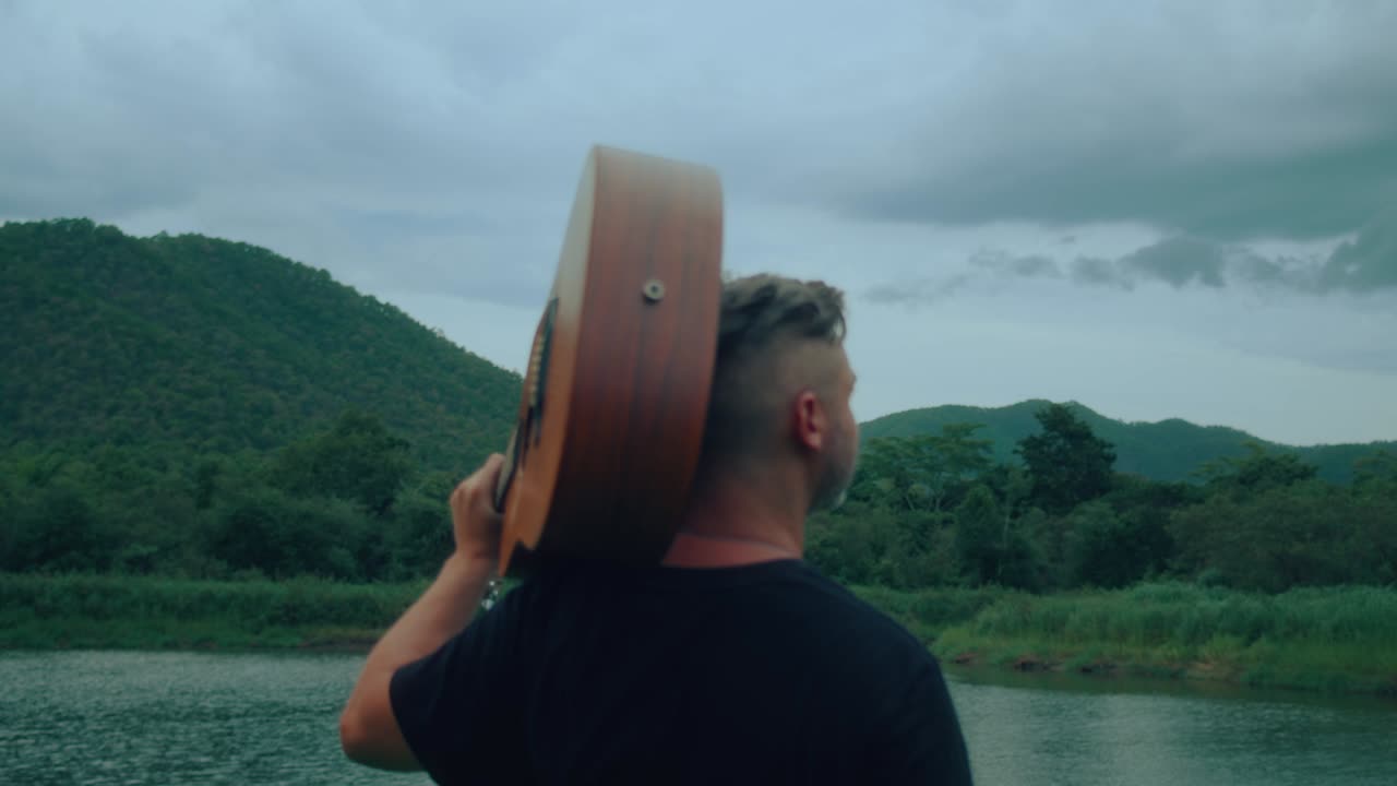 Man with Guitar by the River