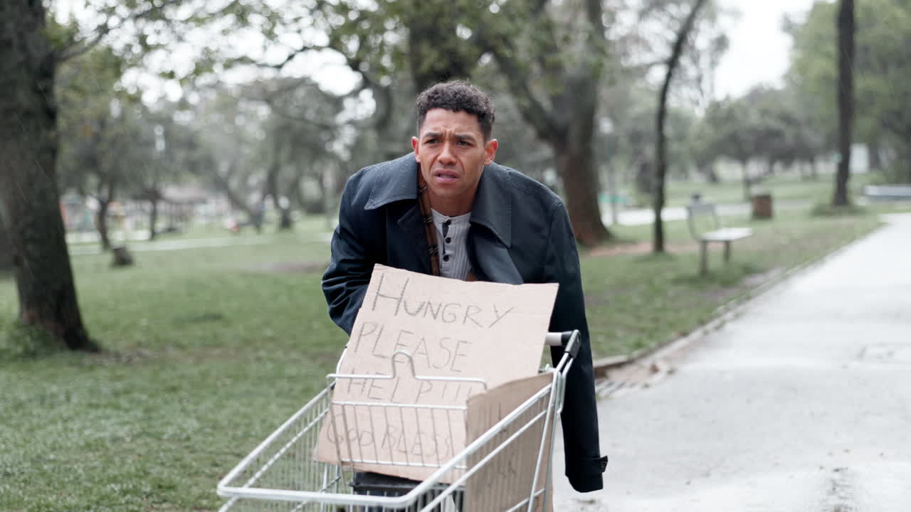 hombre sin hogar mendigando comida en la lluvia