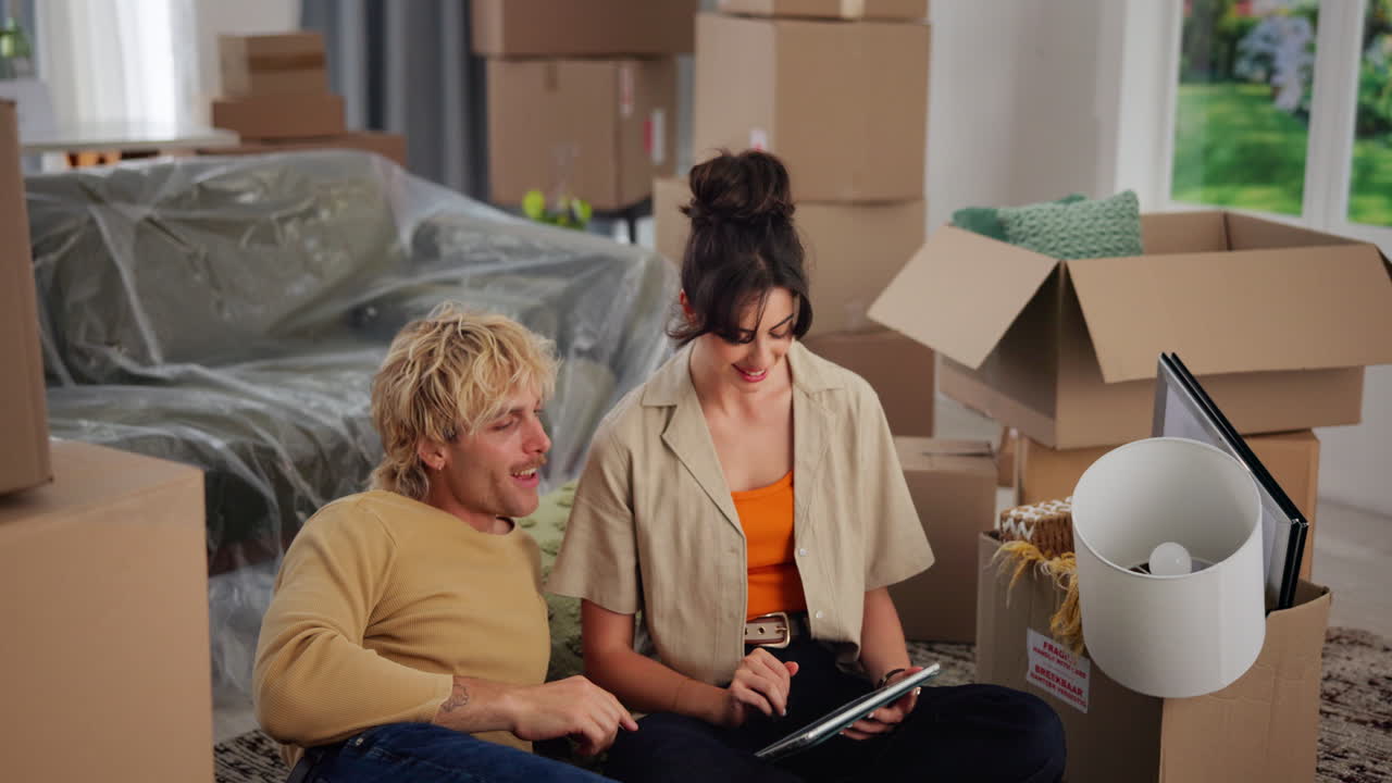 Happy Young Couple Planning Their New Home Move with a Tablet