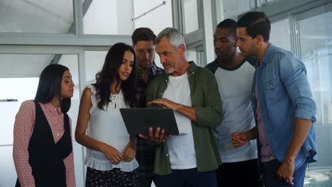 Group-of-executives-discussing-over-laptop