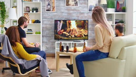 Rückansicht-Von-Freunden,-Die-Auf-Der-Couch-Sitzen-Und-Eine-Fernsehsendung-Ansehen