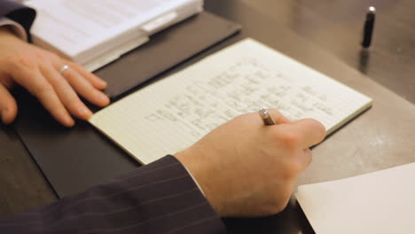 business man writing on a notepad