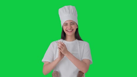 feliz mujer india chef profesional aplaudiendo y apreciando la pantalla verde